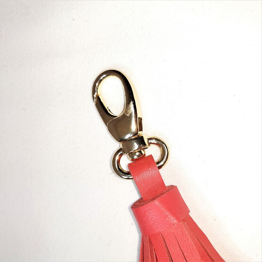 Tasjuweel met lamsleren pompon in oranjerode kleur.