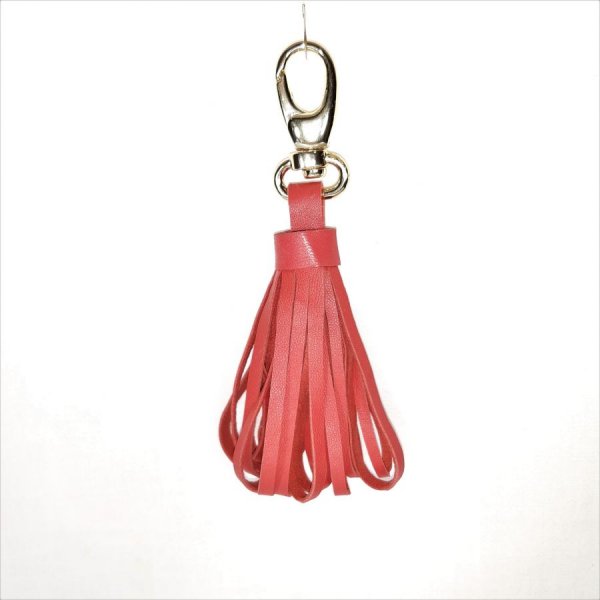 Tasjuweel met lamsleren pompon in oranjerode kleur.