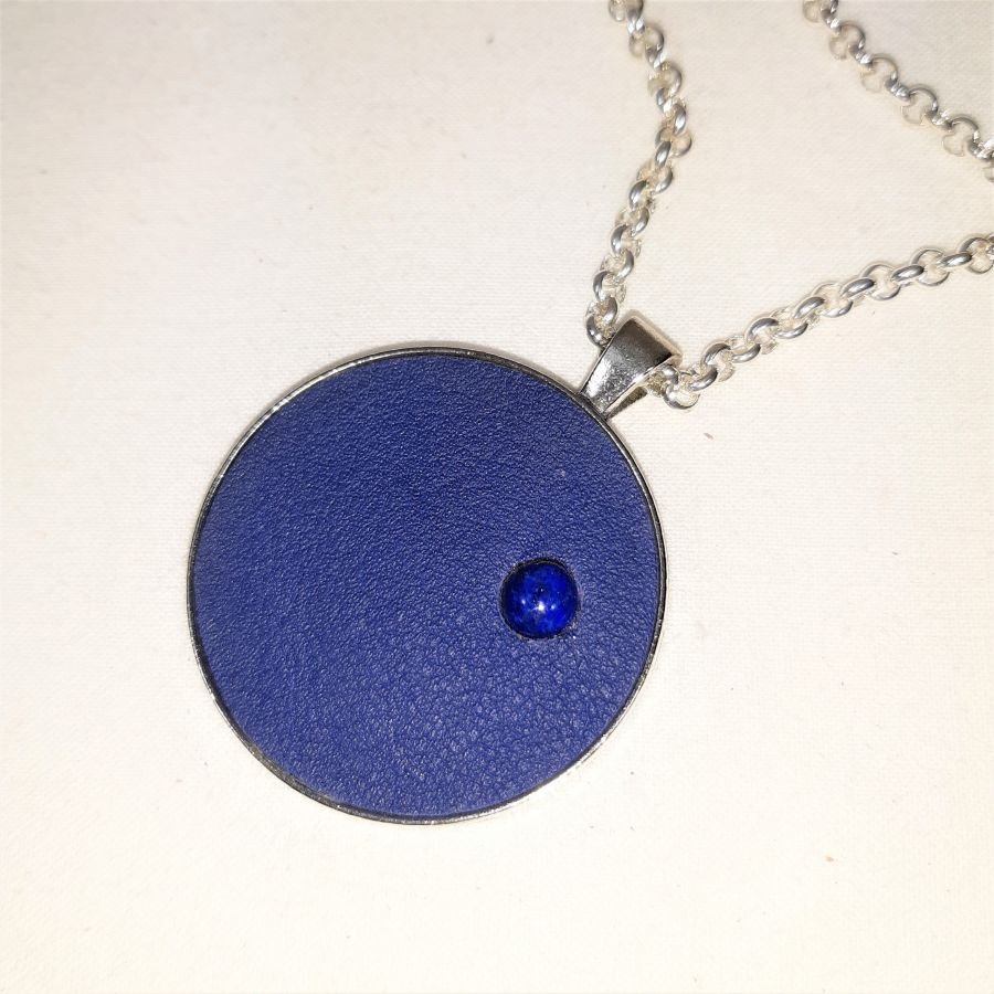 Messing en blauw lederen hanger met lapis lazuli cabochon.