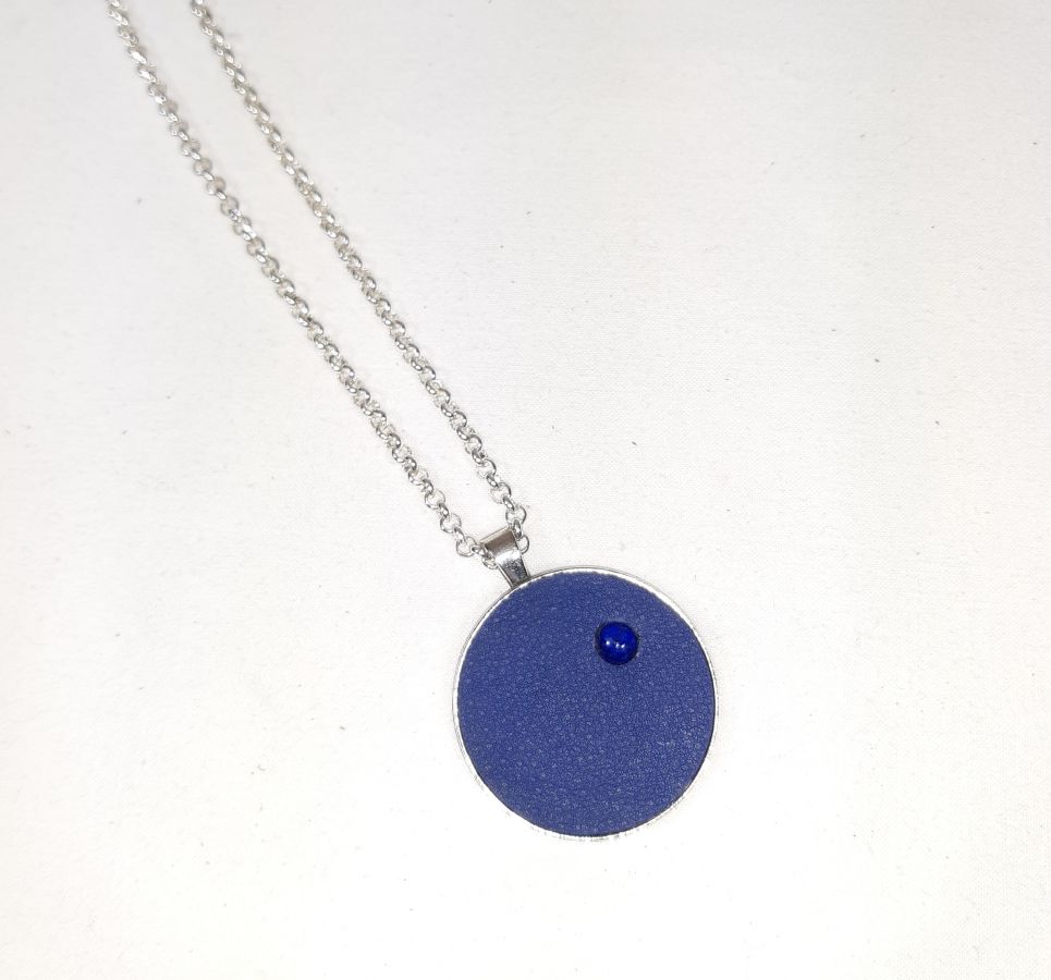 Messing en blauw lederen hanger met lapis lazuli cabochon.