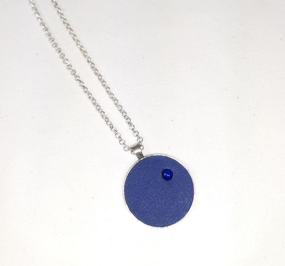 Messing en blauw lederen hanger met lapis lazuli cabochon.